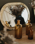 Miroir ovale artisanal laiton doré dans chambre élégante