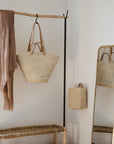 PANIER TRESSÉ EN FIBRE NATURELLE MIS EN SITUATION DANS UNE CHAMBRE À COUCHER