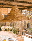 Suspension cloche évasée en fibre naturelle mise en situation dans une verande style méditéranéeen