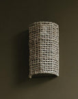 Applique murale tressée en fibre naturelle diffusant une lumière douce