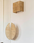 Applique murale KON raphia ajouré associée à un miroir rond dans un intérieur naturel - création Cosydar