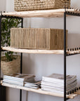 Coffre de rangement LINE en fibre naturelle utilisé comme meuble d'appoint dans un salon bohème