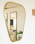 Grand miroir doré accroché au mur dans un salon bohéme