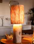 Lampe à poser TANA raphia allumée – lumière douce et tamisée dans un salon bohème – Cosydar