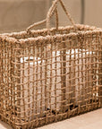 Panier LINE tressé en corde de palmier avec 2 anses posé sur le sol d'une salle de bain