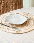 Set de table rond tressé en feuille de palmier sur une table à manger