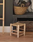 Tabouret Marocain en bois 32cm dans un salon à côté d'une table basse et d'une cheminée