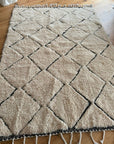 Grand tapis artisanal et laine naturelle sur un parquet dans un salon