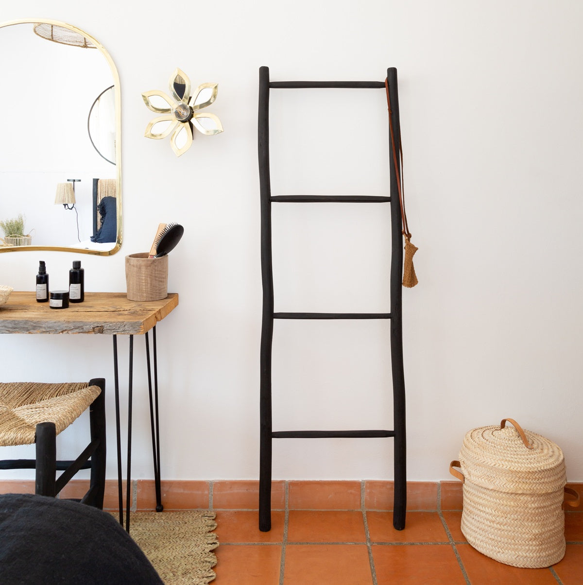 Échelle décorative noire utilisée comme porte-serviettes dans une chambre moderne