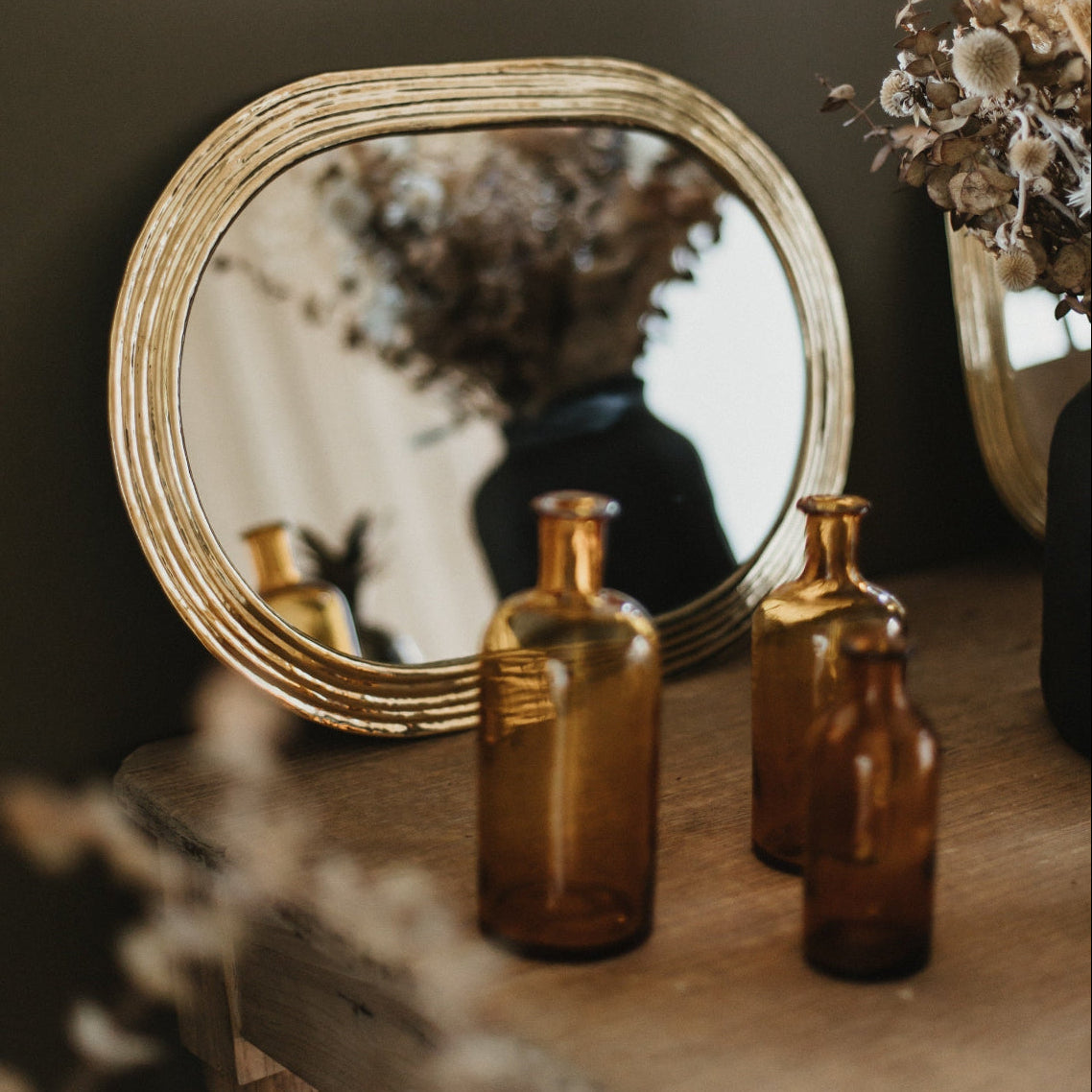 Miroir ovale artisanal laiton doré dans chambre élégante