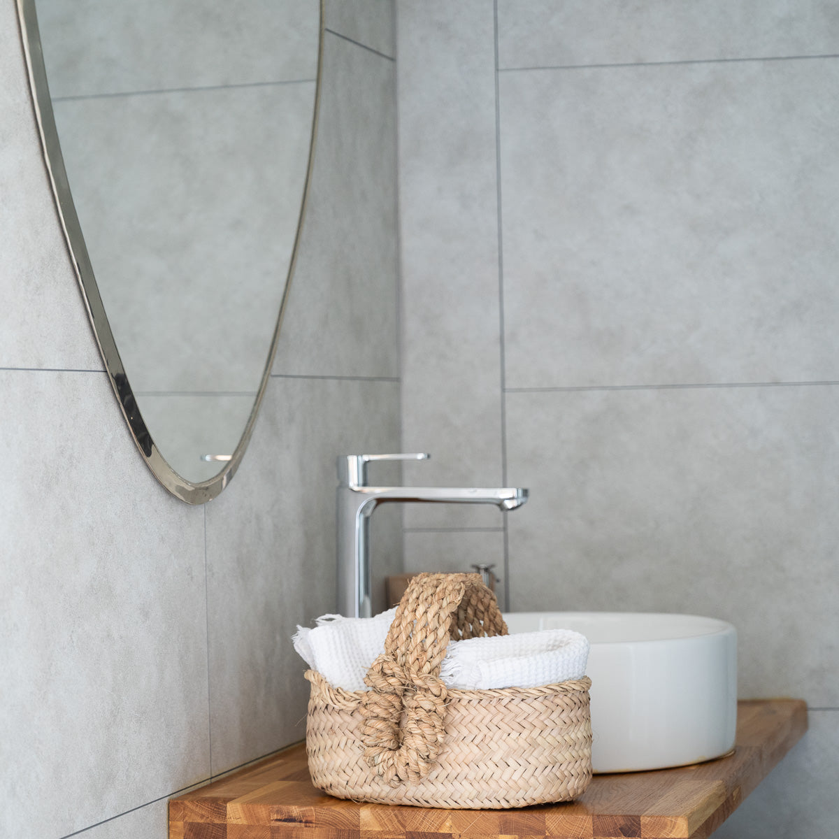 Grand miroir argenté et Panier naturel dans une salle de bain