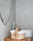 Grand miroir argenté et Panier naturel dans une salle de bain