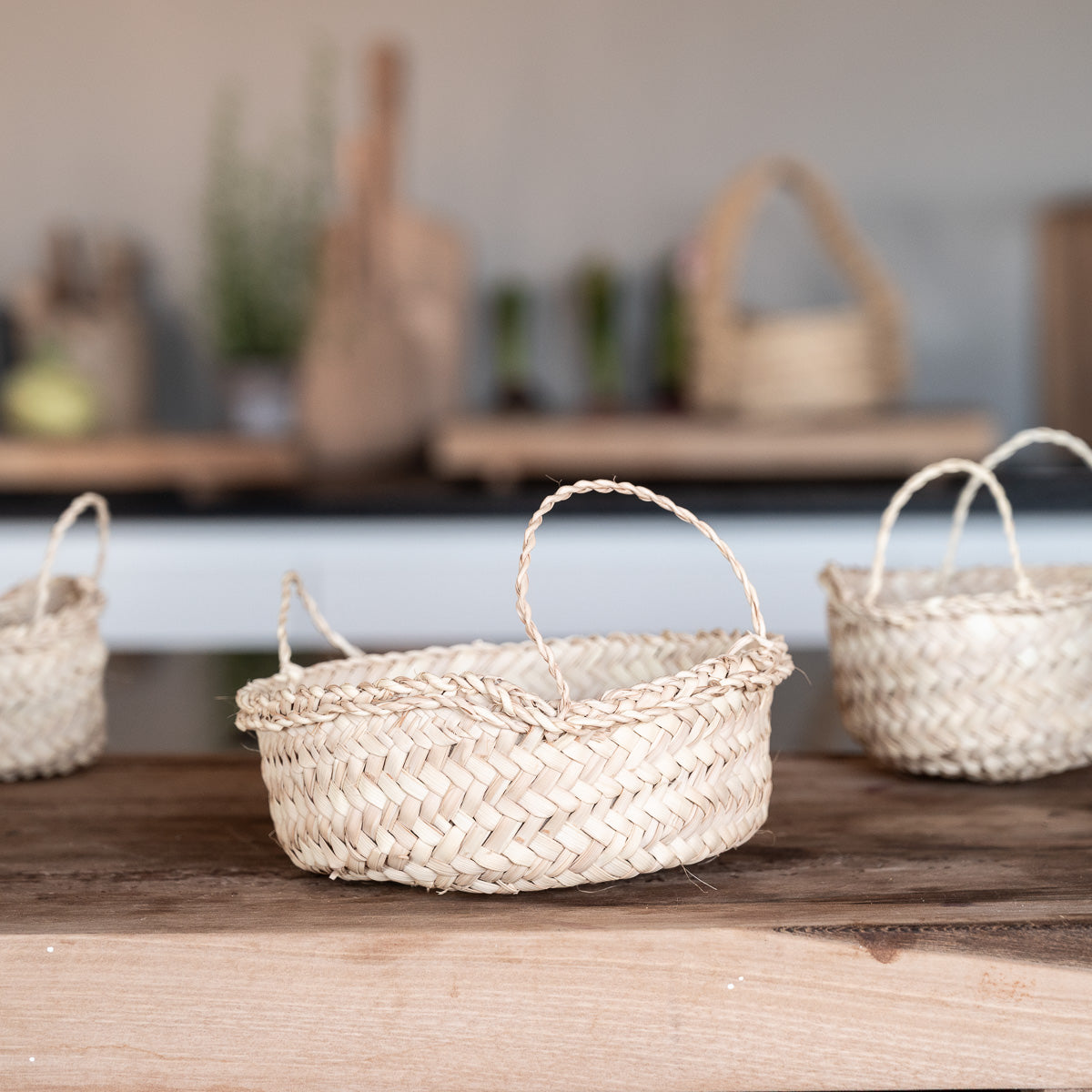 Anses fines tressées à la main sur corbeille artisanale en feuilles de palmier