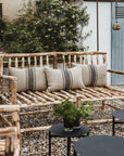 Canapé NAMA en bois brut avec coussins en lin rayé, vue de côté