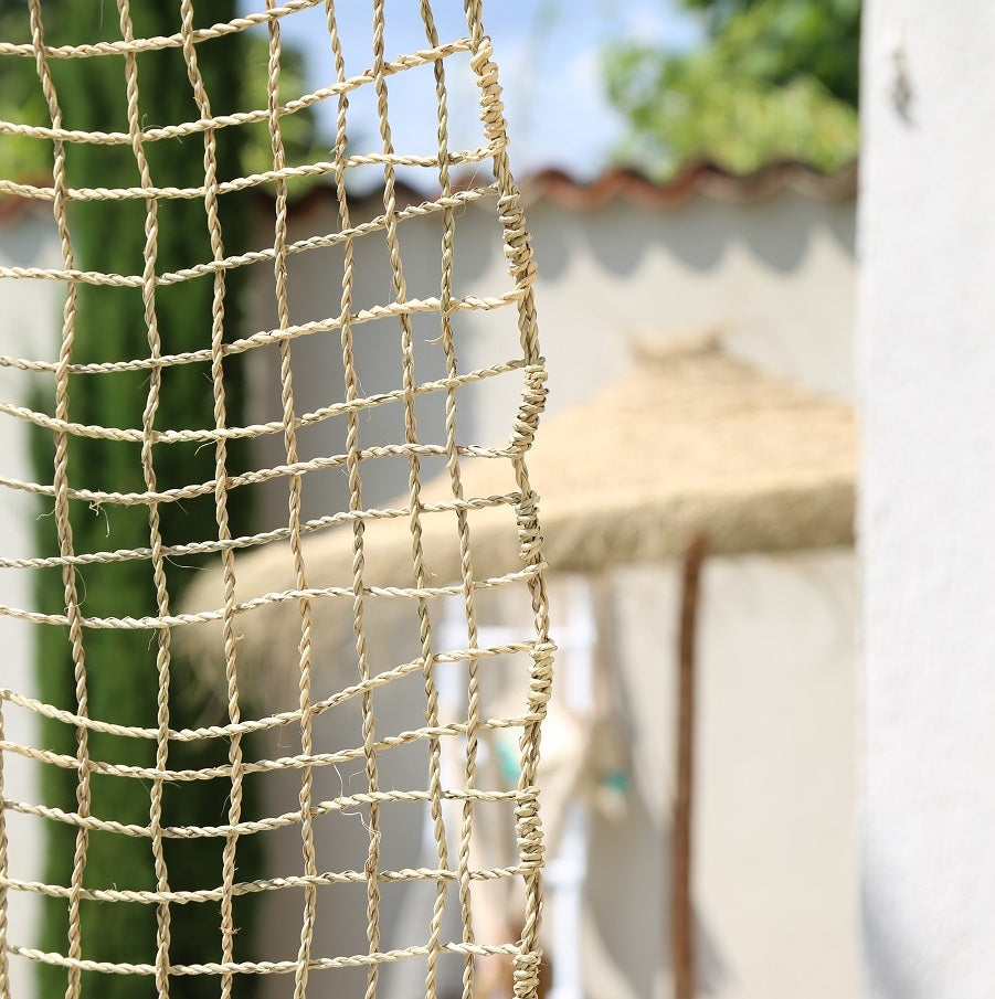 Rideau décoratif en corde de palmier suspendu dans une terrasse couverte