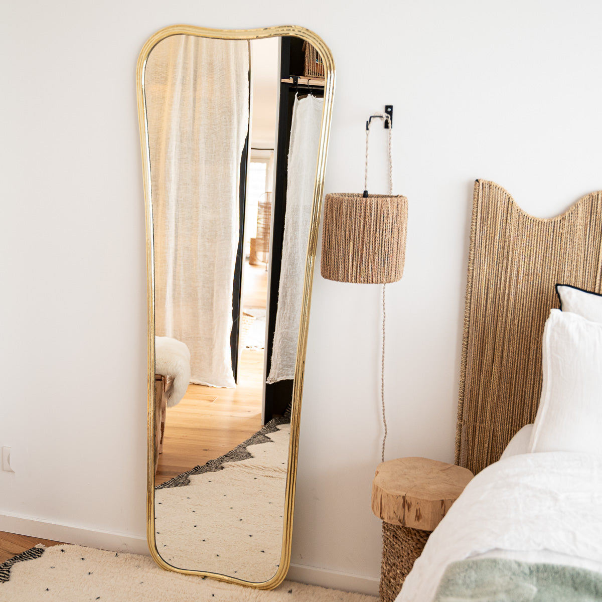 Grand miroir mural en laiton doré dans une ambiance élégante et cosy