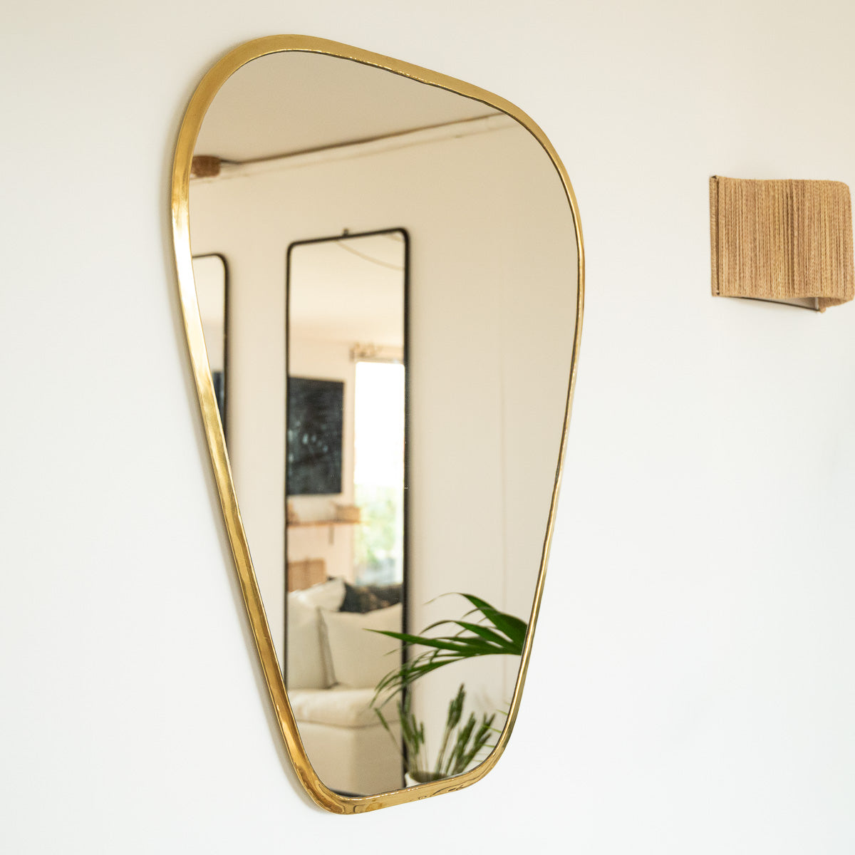 Grand miroir doré accroché au mur dans un salon bohéme