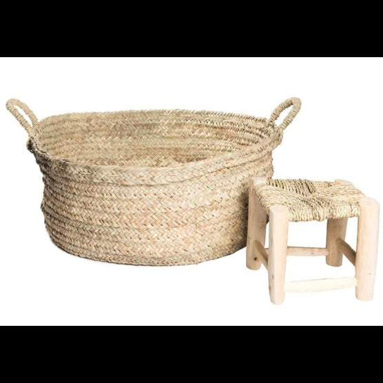 Grand panier tressé en feuille de palmier avec anses tressés - mis en valeur à côté d'un mini tabouret marocain