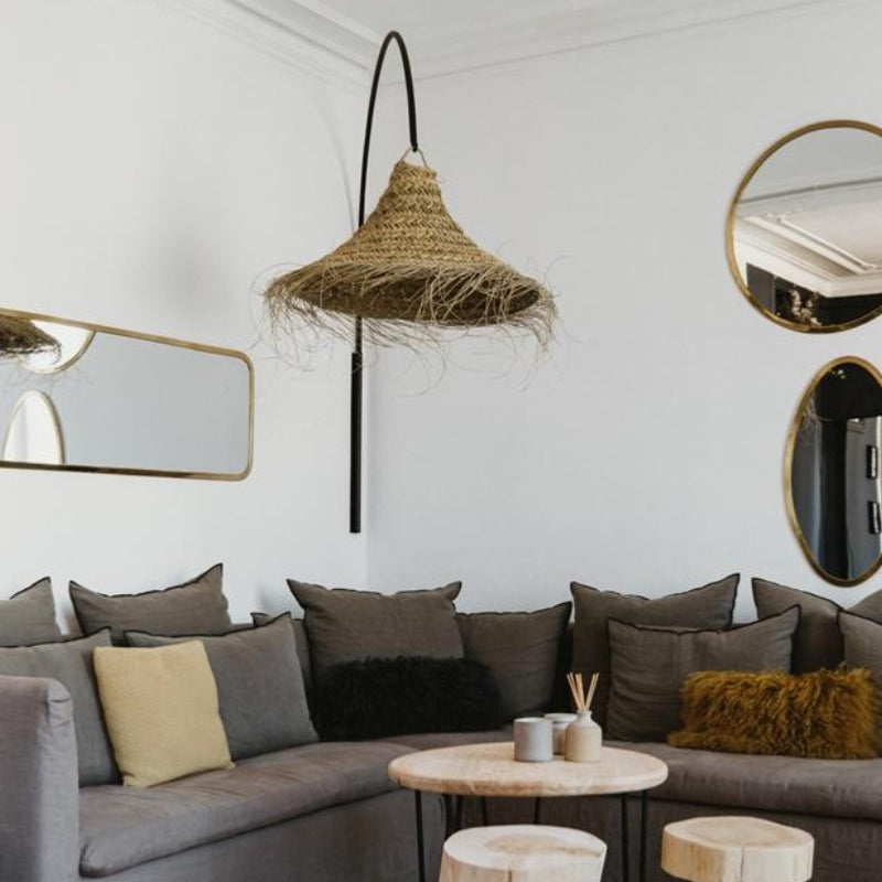 Suspension cloche évasée en fibre naturelle installée dans un salon au style méditerranéen