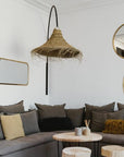 Suspension cloche évasée en fibre naturelle installée dans un salon au style méditerranéen