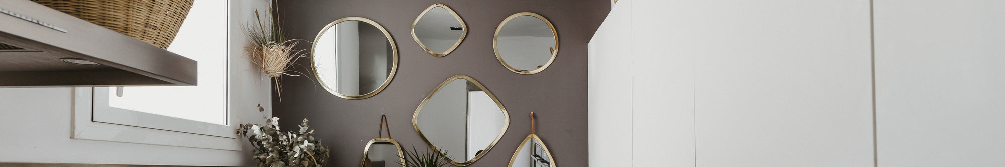 Composition murale de plusieurs miroirs dorés de différentes formes: carré, rond et organique