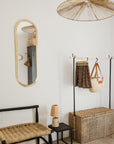 Miroir ovale doré Cosydar accroché au mur, apportant une touche chic et lumineuse à la pièce.