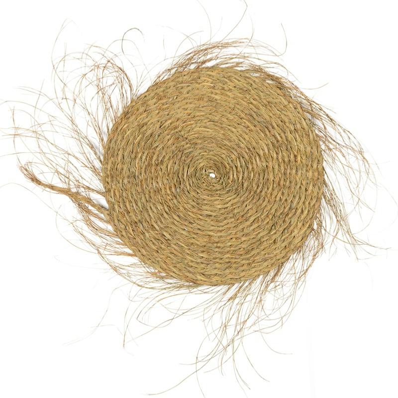 Natte ronde tressée en fibre naturelle sur fond blanc