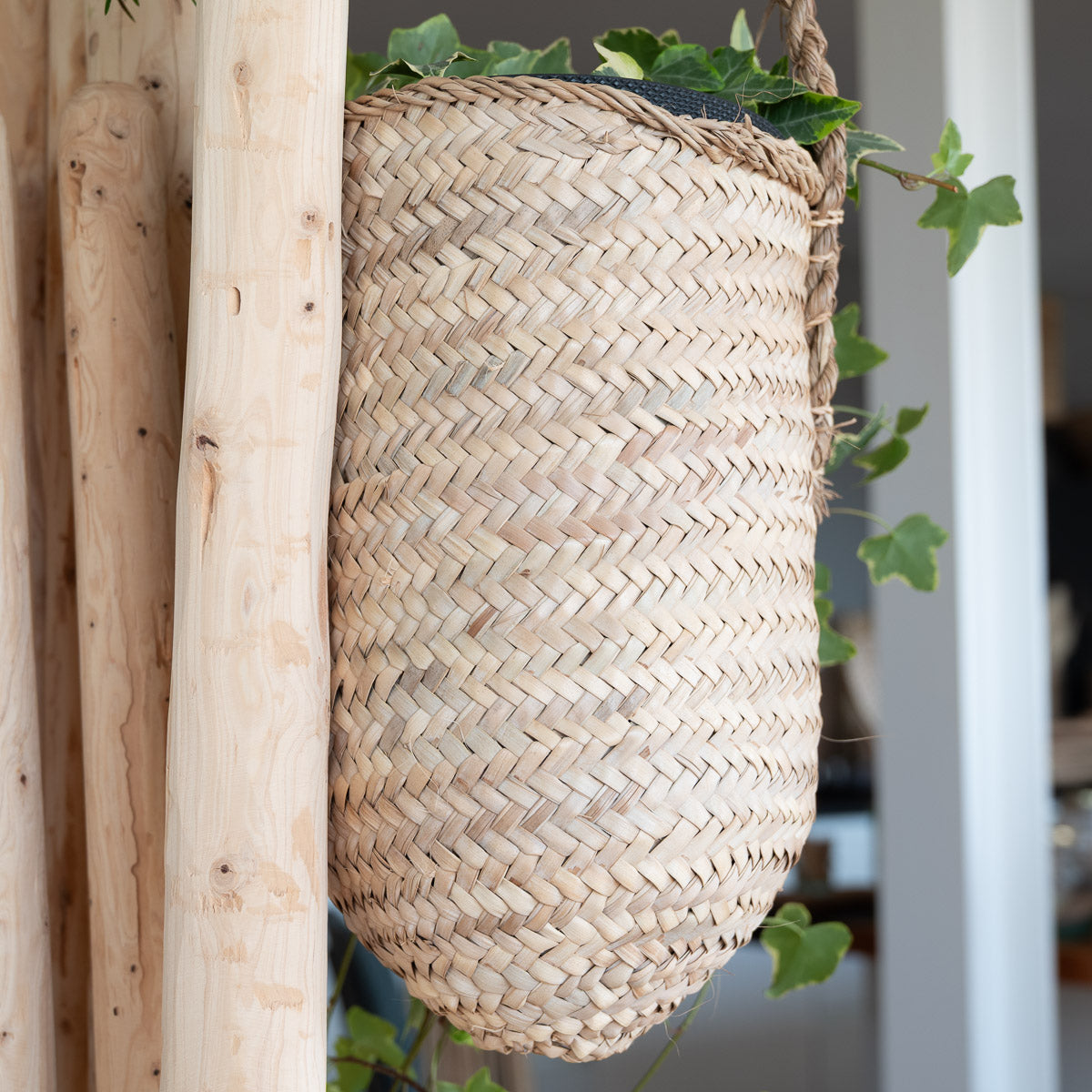 Panier suspendu en feuille de palmier - vue d'ensemble dans un intérieur bohème