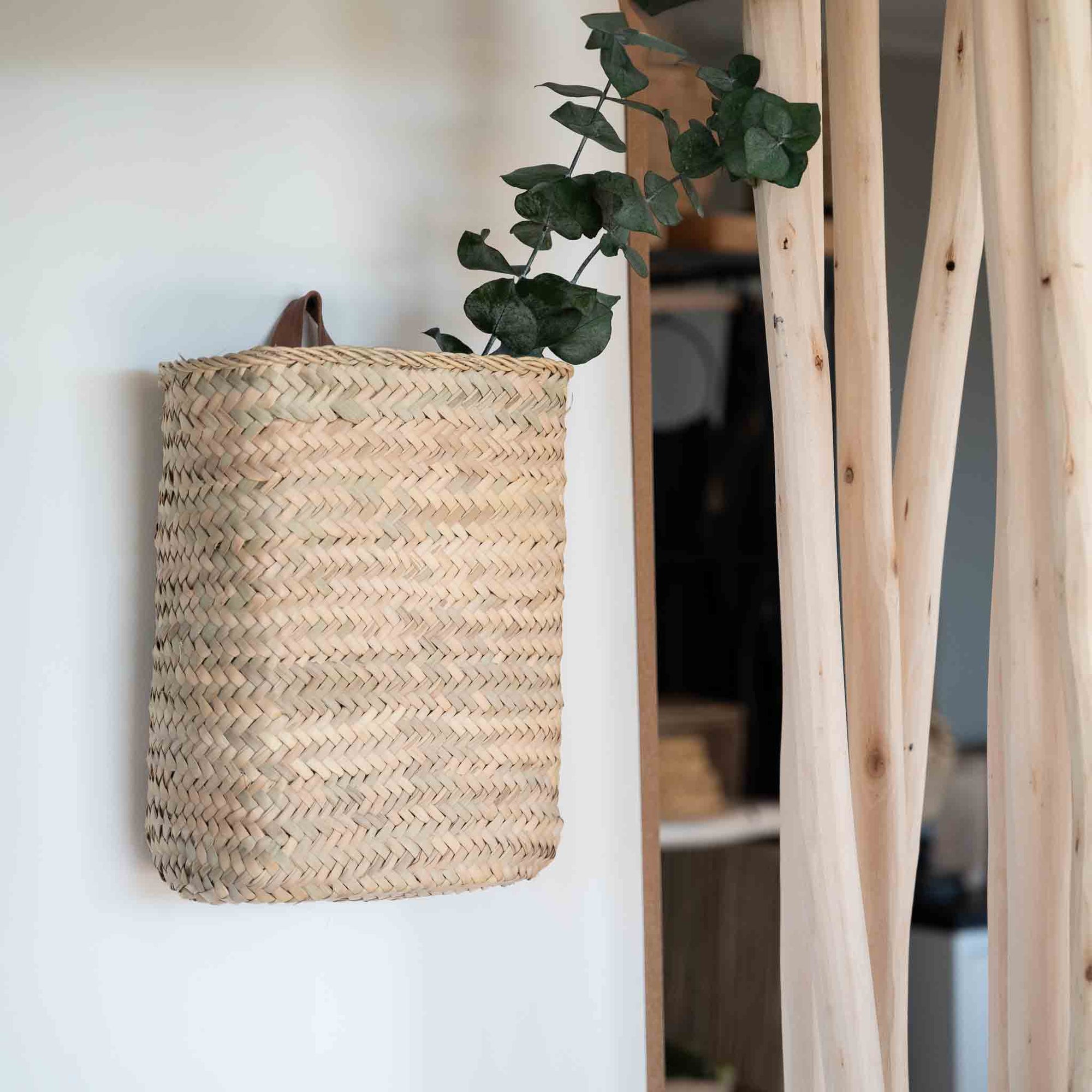 Panier tressé mural en feuille de palmier avec anse en cuir accroché au mur