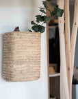 Panier tressé mural en feuille de palmier avec anse en cuir accroché au mur