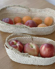 Paniéres ovales CLARA tressée artisanalement présentées avec des fruits dans une cuisine COSYDAR