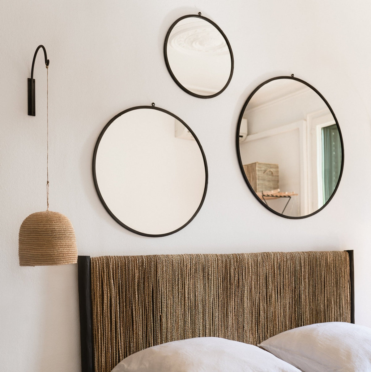Potence murale TEKU en métal noir et suspension en raphia en lampe de chevet, sous une composition de miroirs ronds – COSYDAR