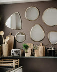 Égouttoir en Bois Artisanal dans une cuisine avec un mur de miroirs argentés et autres accessoires de cuisine en bois et en fibre naturelle