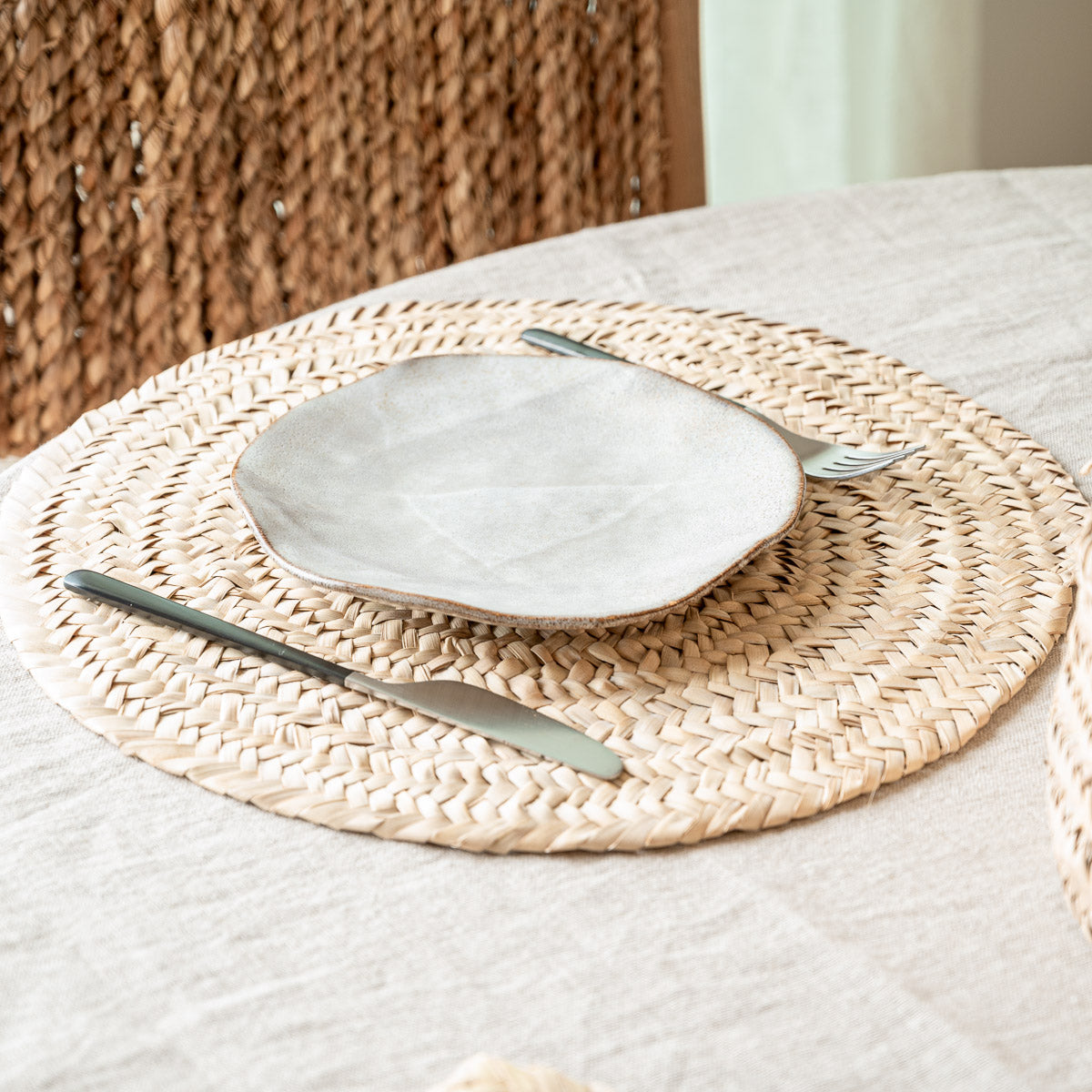 Set de table rond tressé en feuille de palmier sur une table à manger