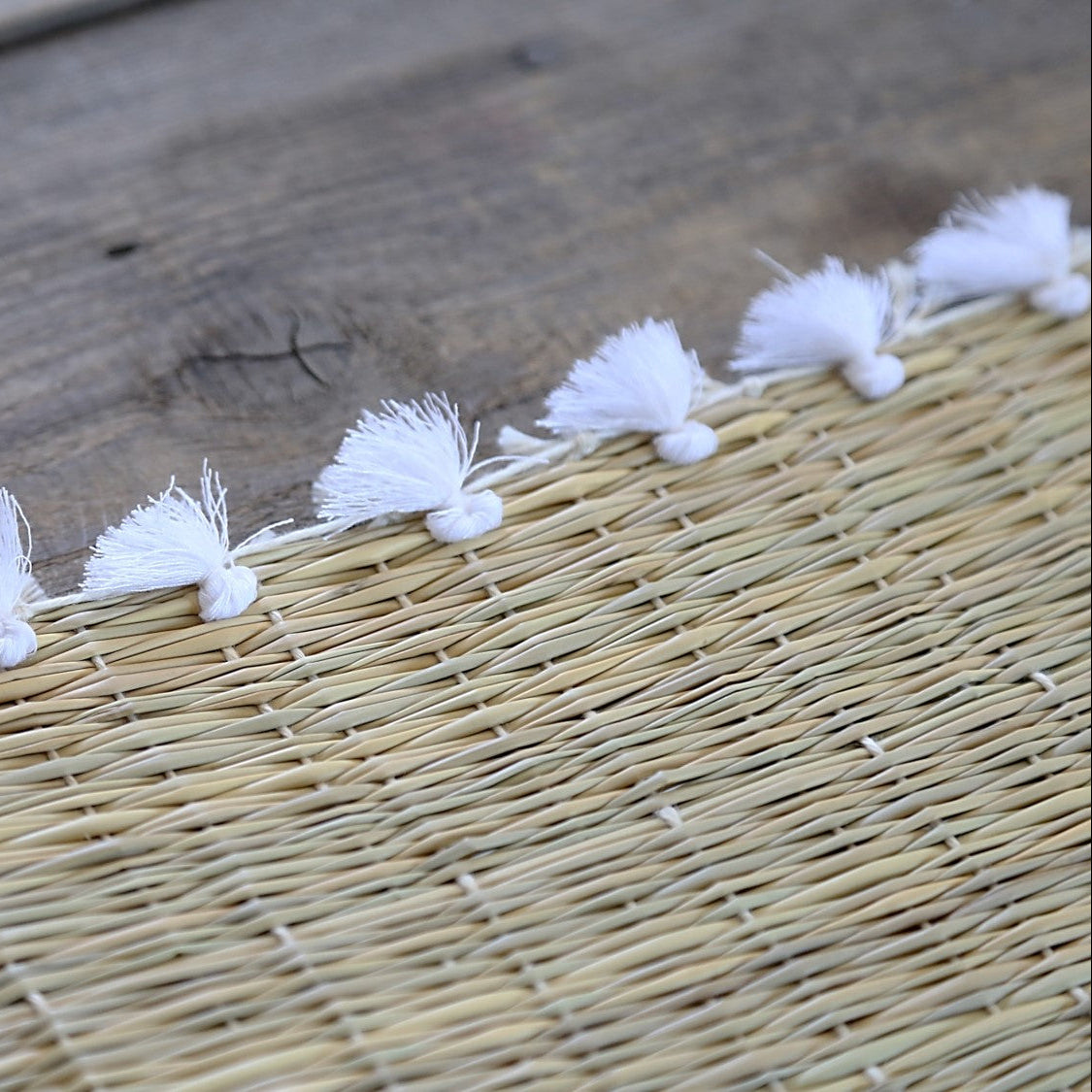 Set de table tressé en fibre naturelle avec pompons blancs - 40x30 cm