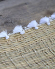Set de table tressé en fibre naturelle avec pompons blancs - 40x30 cm