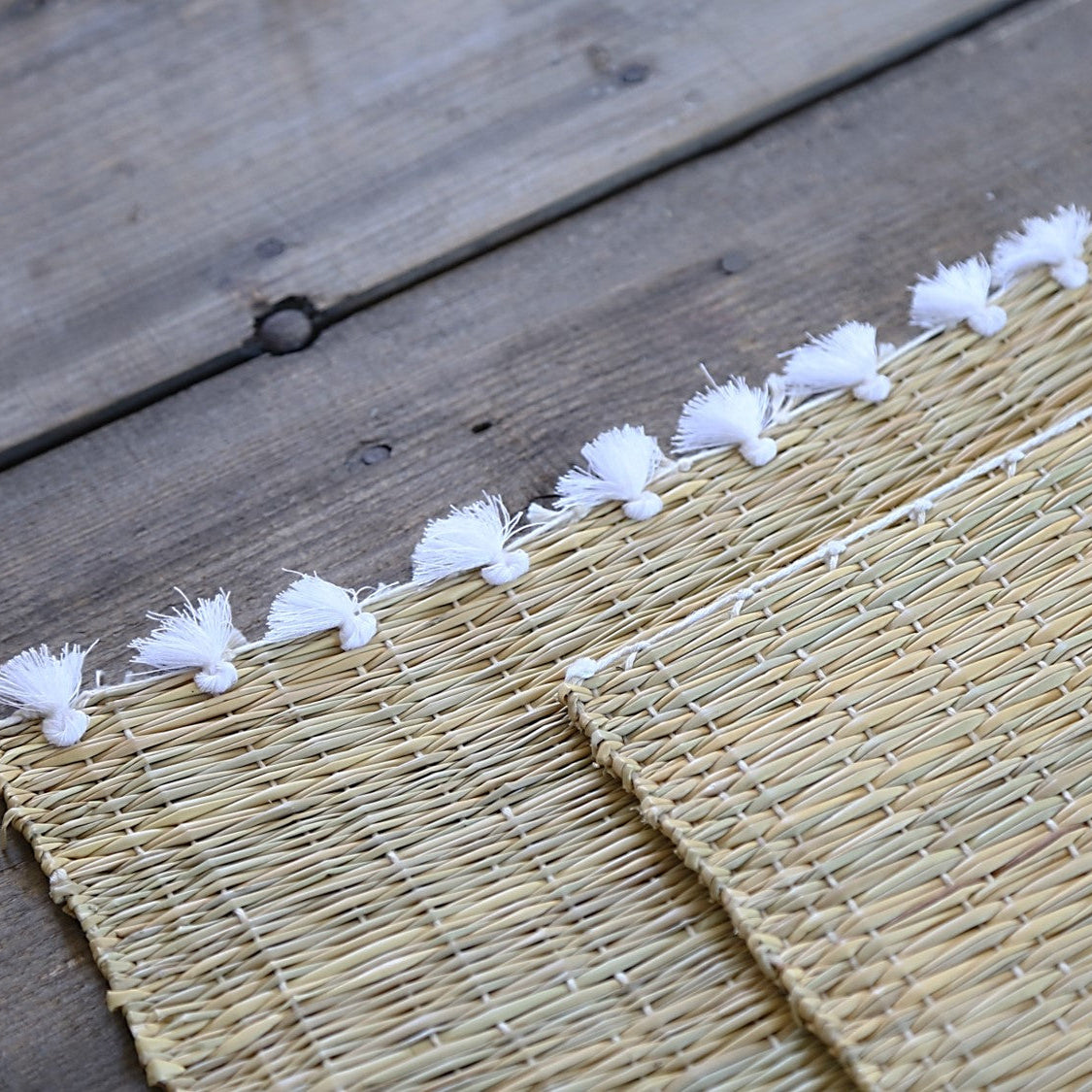 Set de table tressé en fibre naturelle avec pompons blancs - 40x30 cm