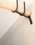 Détail support mural en V noir mat avec bâton de tringle bois clair Cosydar