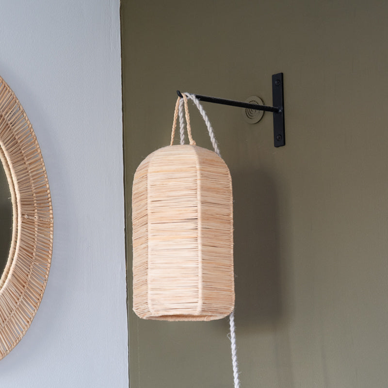 Suspension tressée suspendue sur une patére en métal dans une chambre