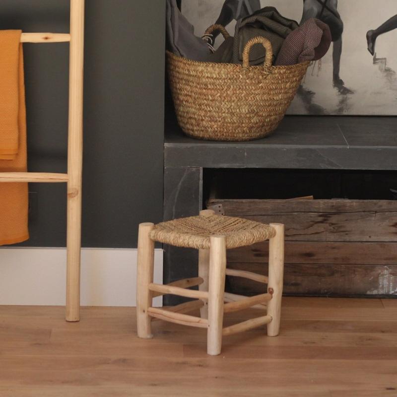 Tabouret Marocain en bois 32cm dans un salon à côté d'une table basse et d'une cheminée