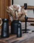 Vases et bougeoires noirs sur une table basse en bois bohéme